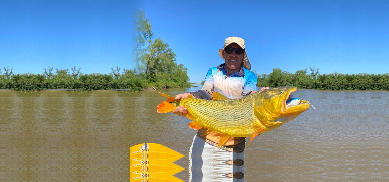 Pescador sosteniendo un dorado en la lancha, Esquina, Corrientes