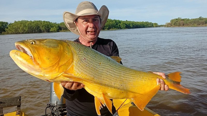 Pescador con sombrero muestra un dorado en el río Paraná, Esquina, Corrientes