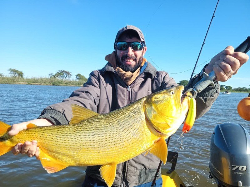Pescador con gorra y un dorado pescado con señuelo, Esquina, Corrientes