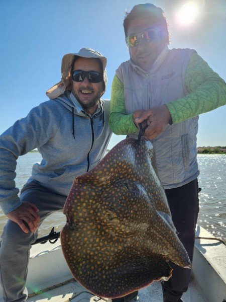 Dos pescadores con una raya de río en la lancha, Esquina, Corrientes