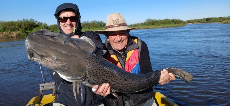 Dos pescadores con un surubí en el río, Esquina, Corrientes