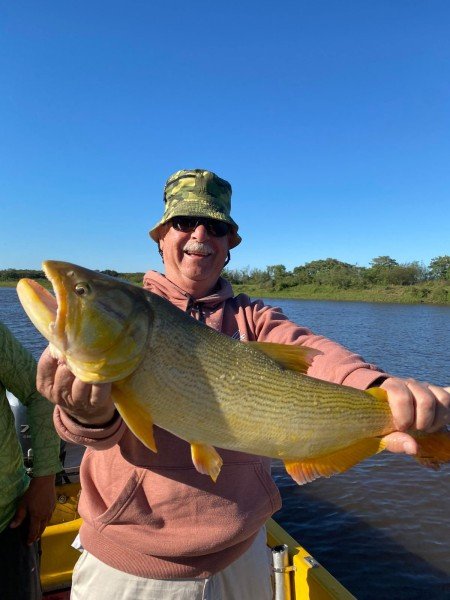 Pescador con gorro muestra su captura en la lancha, Esquina, Corrientes