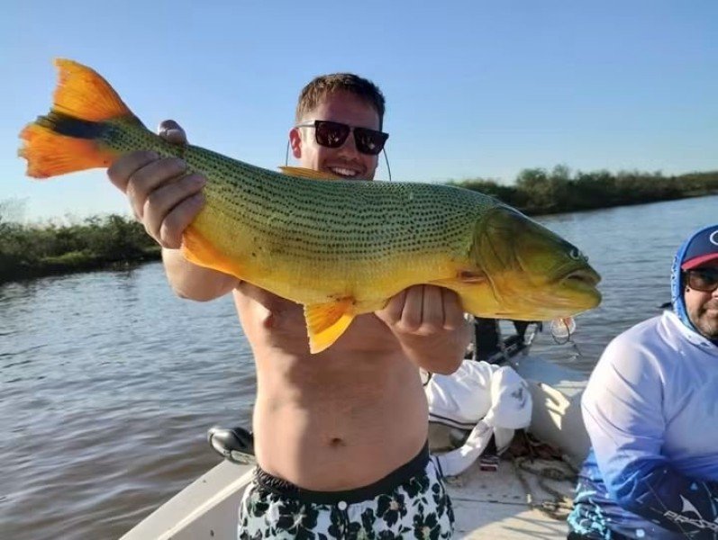 Pescador muestra un dorado en la lancha, Esquina, Corrientes